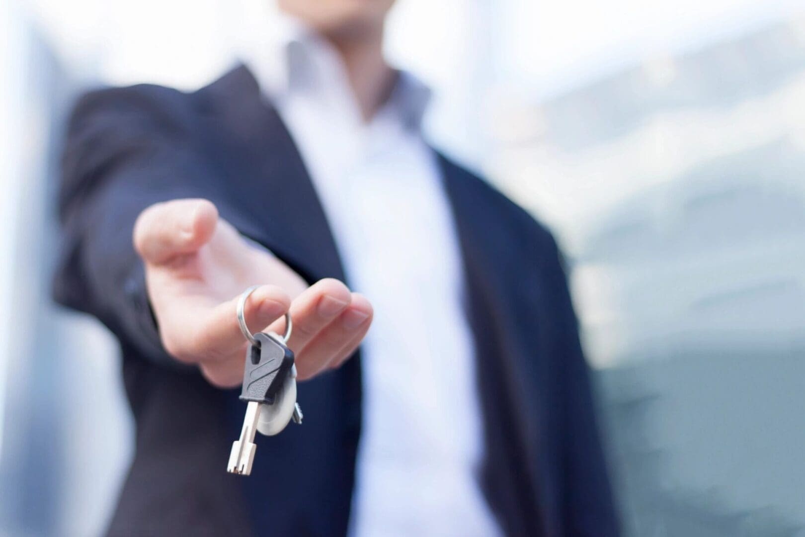 A man holding out his keys in front of him.