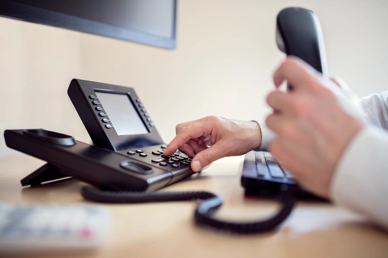 A person is using the phone on a desk